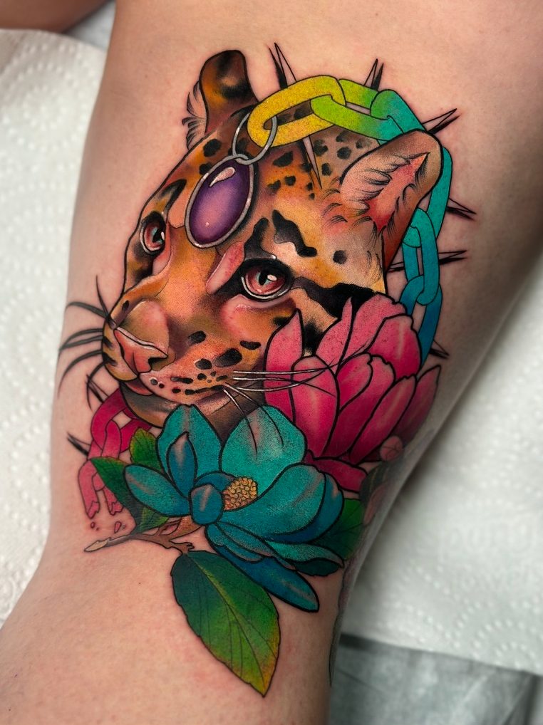 Clouded leopard and peonies tattoo on the thigh by Tia Berry, colour tattoo artist in Vancouver