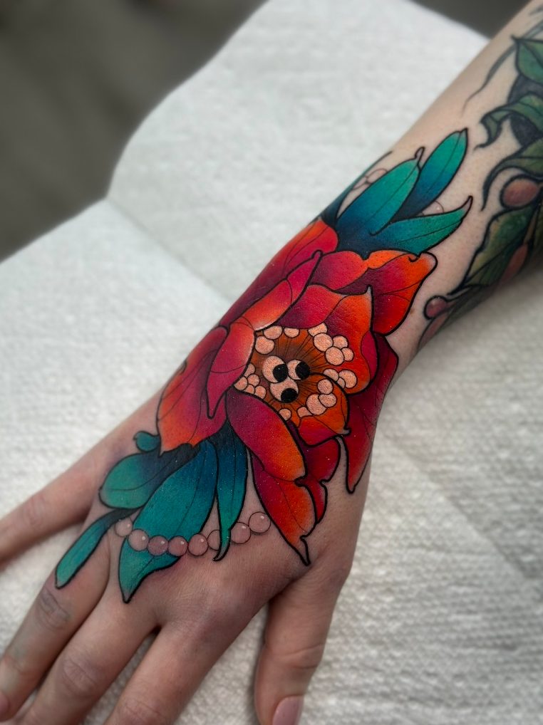 Bloom and pearls tattoo on the hand by Tia Berry, colour tattoo artist in Vancouver