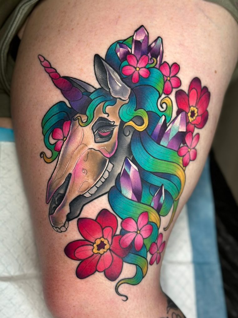 Unicorn skull and florals tattoo on the thigh by Tia Berry, colour tattoo artist in Vancouver