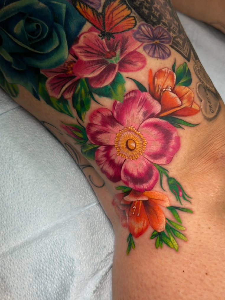 Wild rose and lilies tattoo on the leg by Tia Berry, colour tattoo artist in Vancouver